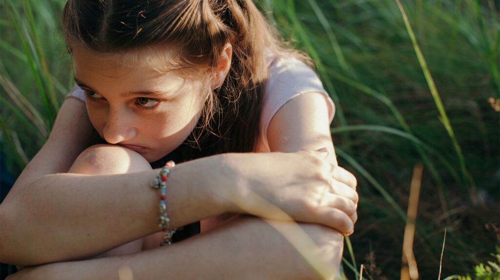 scared young girl with ptsd sitting alone