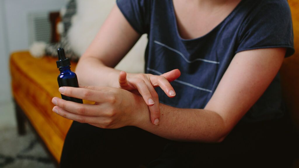 Close-up of a person applying essential oil