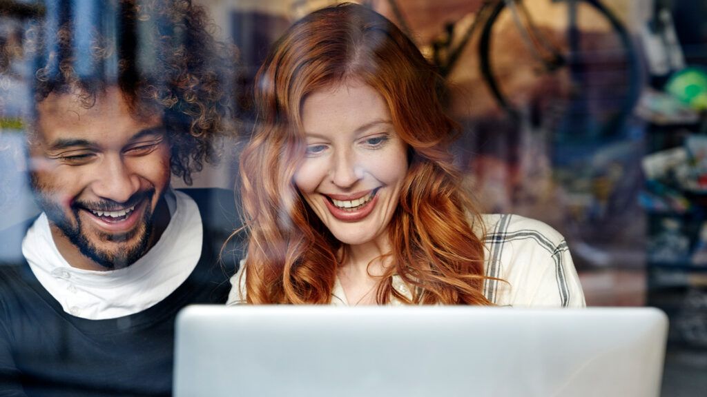 Couple looking at online marriage counseling services on their laptop