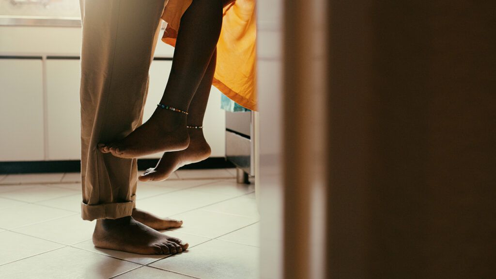 Cropped view of couple's feet in kitchen