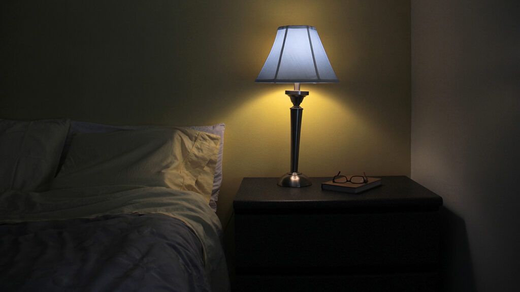 Dark bedroom illuminated by lamp