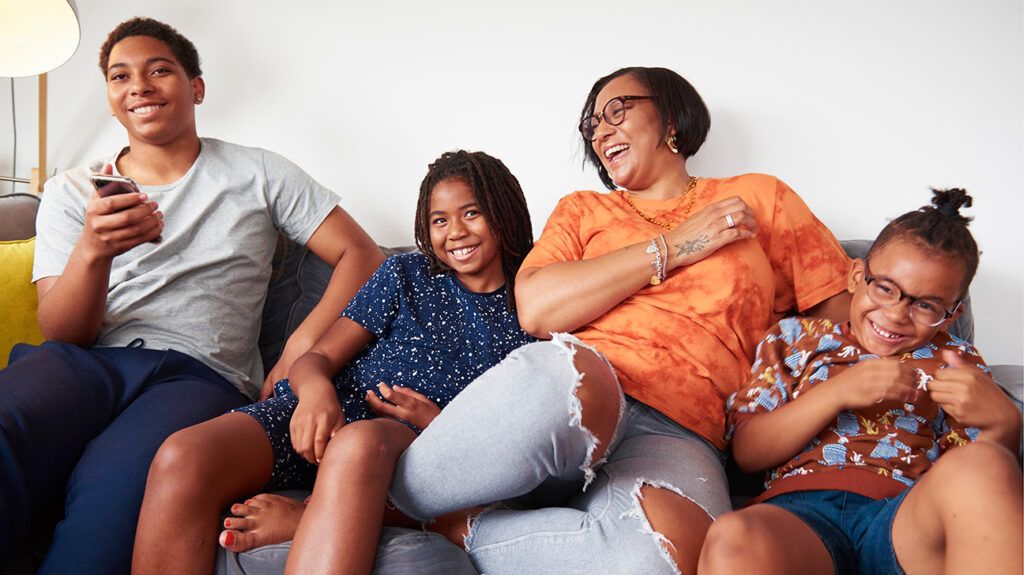 Family laughing on couch