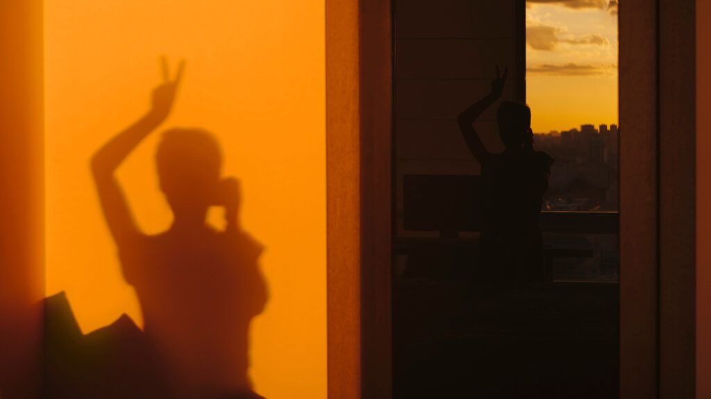 Female's shadow holding peace sign