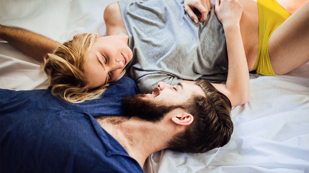 young couple cuddling in bed