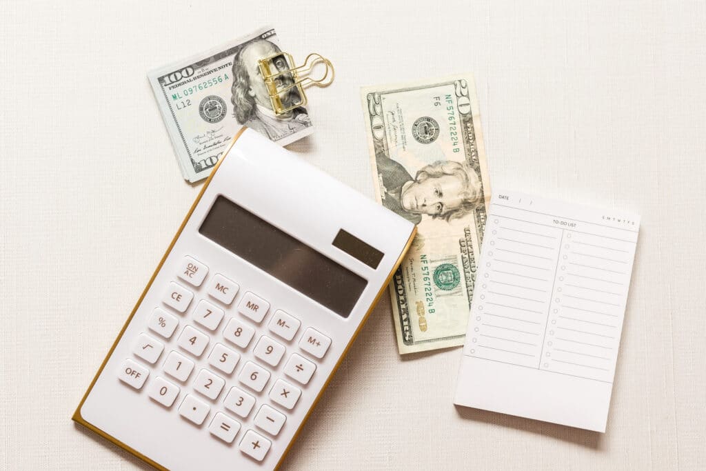 money and calculator on table. How to Avoid PayPal Fees