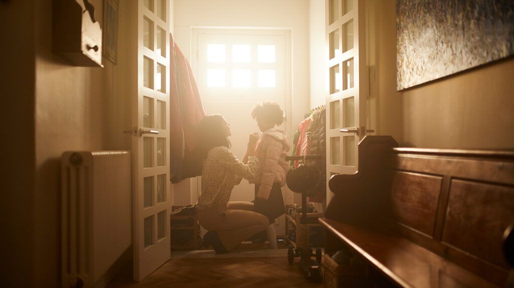 Mother helping her kid get ready for school