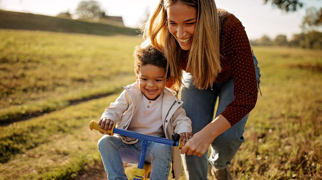 Mother playing with son riding bike