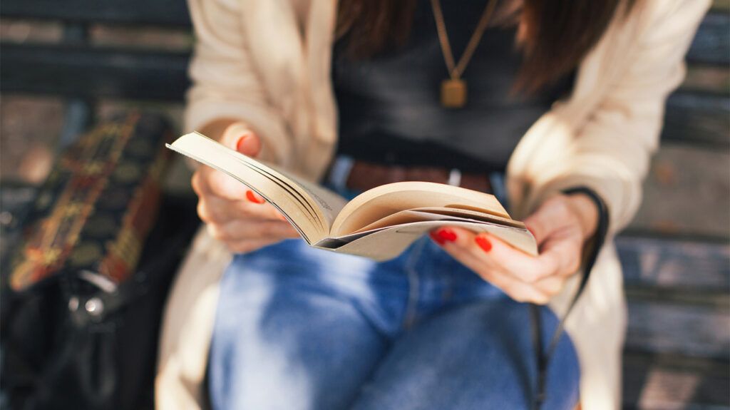 Woman sitting outside reading a book