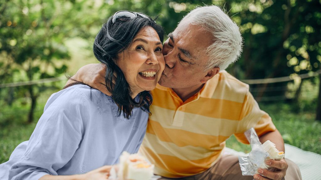 Happy older couple husband kissing wife on cheek