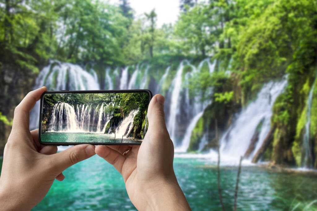 side hustles for introverts - this is a stock photo that I bought of a person taking a picture of a waterfall